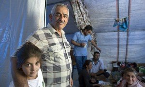 Nissan with his granddaughter and other family members in their tent in Erbil.