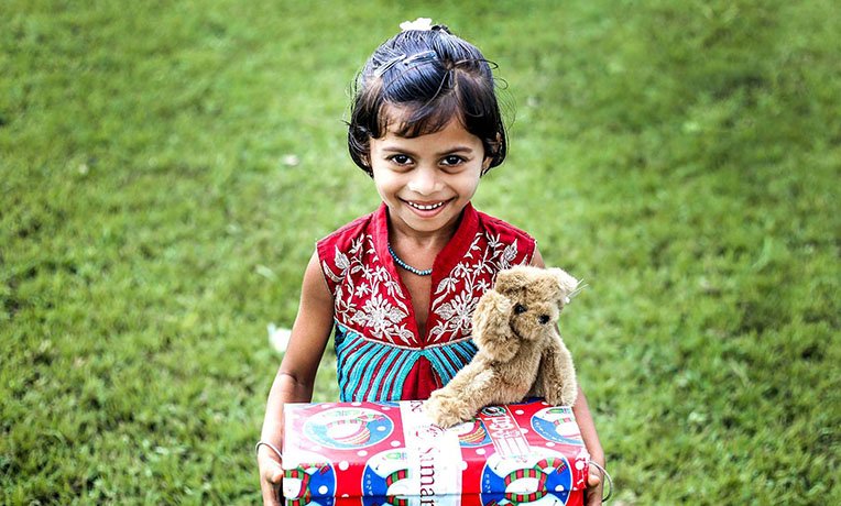Child with shoebox and teddy