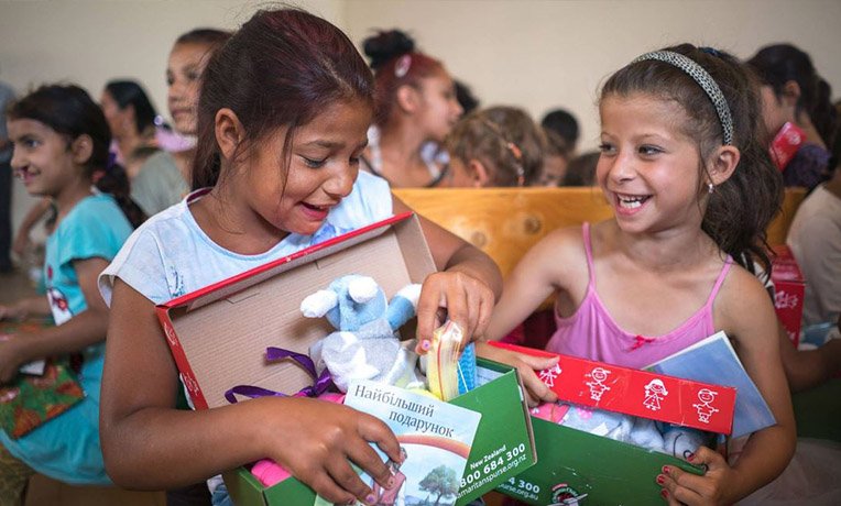 Girls laughing as they explore their shoeboxes