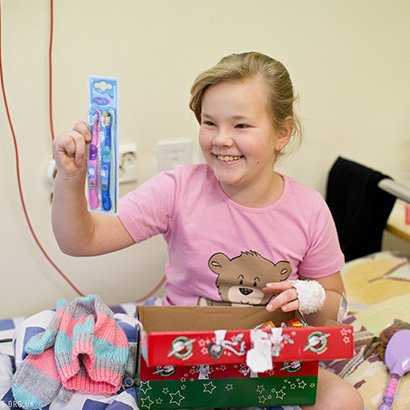 Girl in hospital with shoebox gift