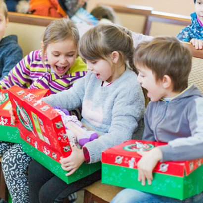 Group of children looking at shoebox gifts in Moldova
