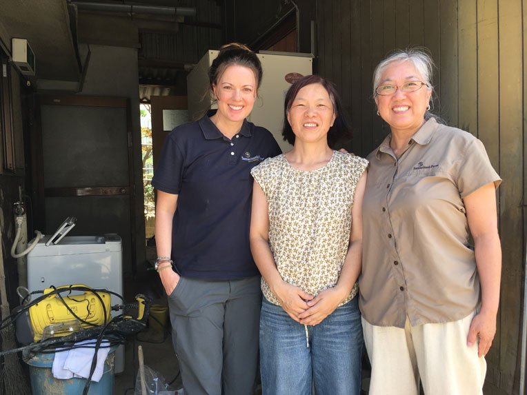 Some of the Samaritan's Purse team stand with homeowner Rumiko Hironishi (centre). Volunteers from the Christ Church Kure volunteer centre helped clean up a room on her first floor.