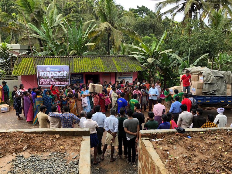 Families prepare to receive emergency relief supplies during a distribution in Northern Kerala.