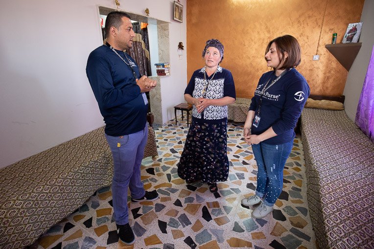 Anna (centre) and the Samaritan's Purse staff talk and pray together in her newly restored home.