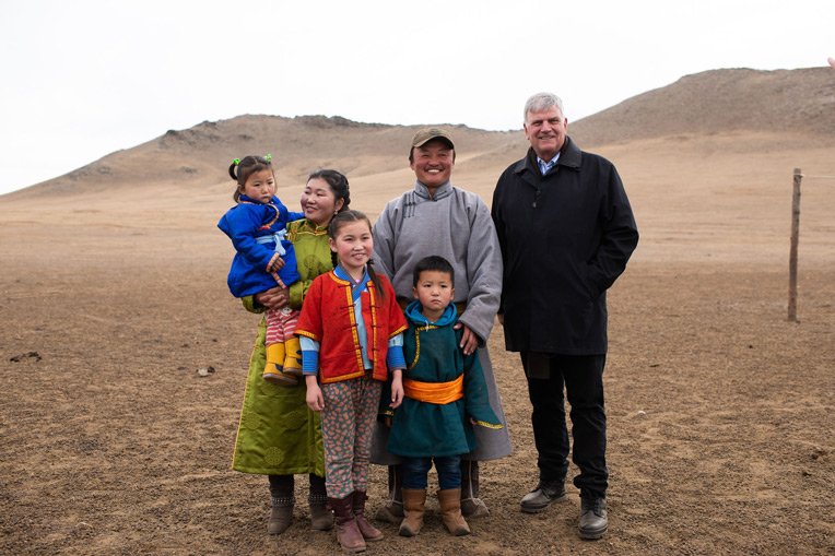 Franklin Graham stands with Ulzii’s family in the grasslands of Mongolia’s Tuv Province. Ulzii (far left) is held by her mother Myadagaa and father Adiyaa, as her sister Tumee and brother Tulgaa stand by.
