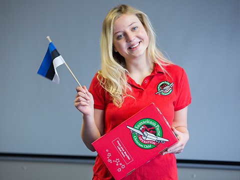 Shoebox recipient Pille holding a shoebox and the Estonian Flag