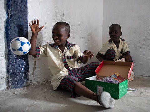 boy plays with football from shoebox gift