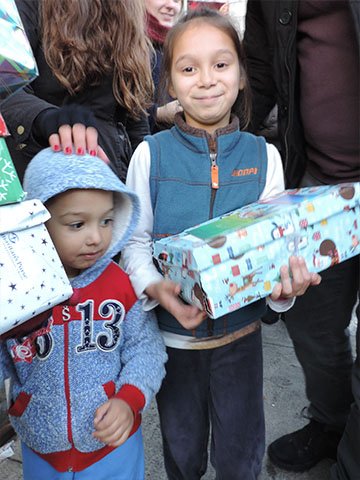 Children in a crowd with shoebox gifts