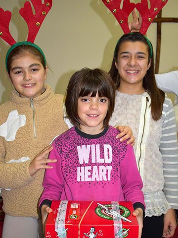 Girls with shoebox gift and reindeer antler