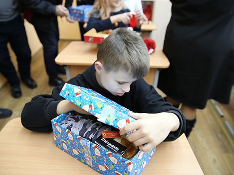 Boy with visual impairment feels his shoebox gifts