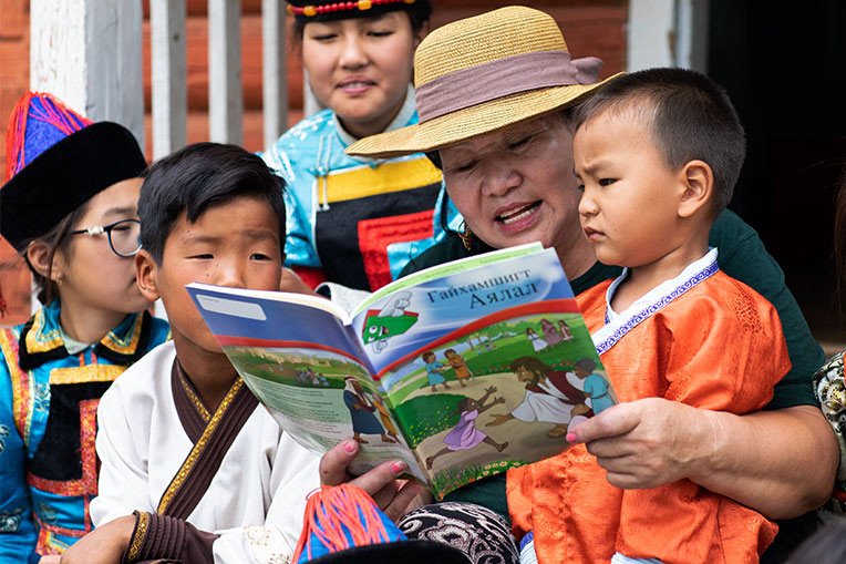 TUYA SHARES THE GOSPEL WITH CHILDREN OF THE UNREACHED BURYAT PEOPLE GROUP USING THE GREATEST JOURNEY WORKBOOK.