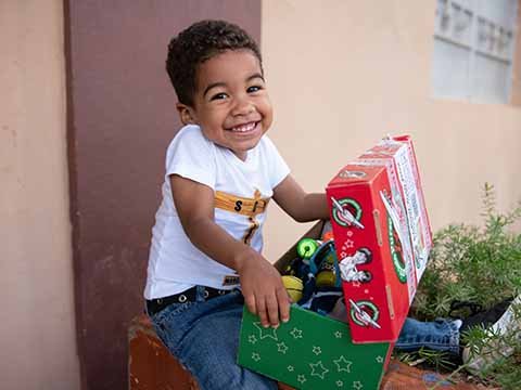 boy with shoebox gift smiles