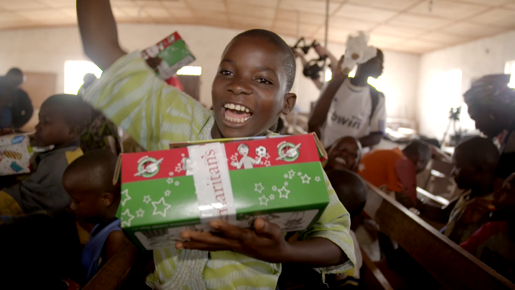 Boy with shoebox cheers in Liberia