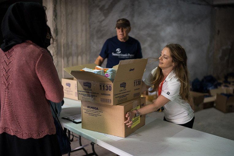 DART member Michelle Mcilveen helps distribute relief items to a mother in need.