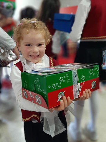 Young girl smiles with shoebox gift