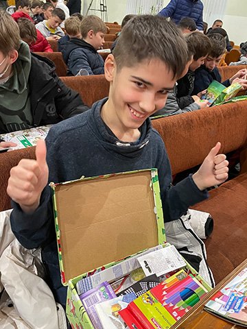 boy gives thumbs up to shoebox