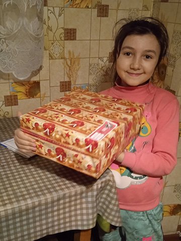 girl holing wrapped shoebox