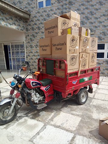 Shoeboxes being transported by moterbike