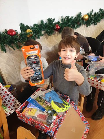 Boy gives a big thumbs up to new toy cars