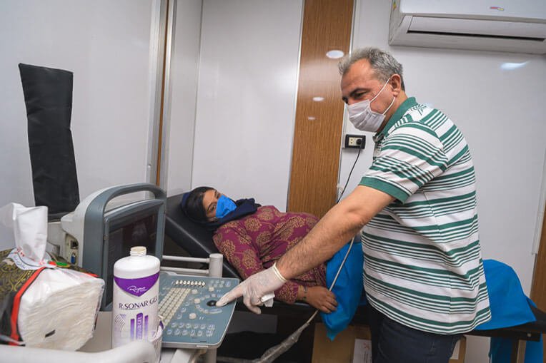 A clinic staff member performs an ultrasound on Aisha.