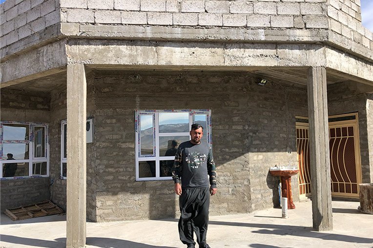 Amar proudly stands in front of his home that Samaritan’s Purse rebuilt.