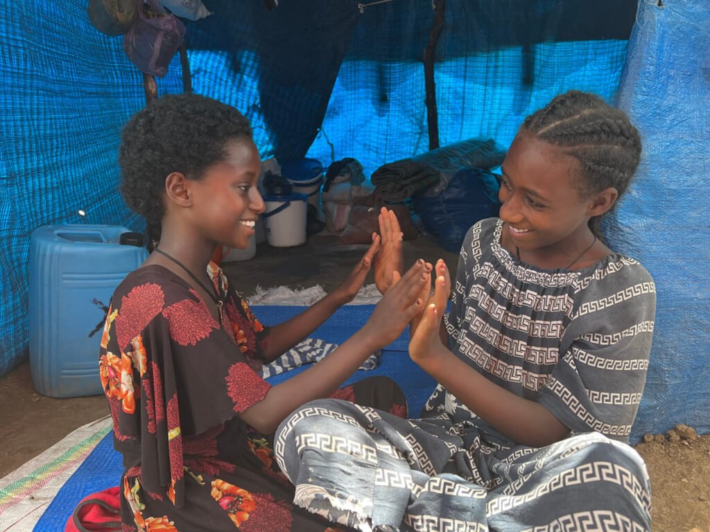 Miheret is happy to be healthy enough to enjoy new friends even in the midst of the IDP camp.