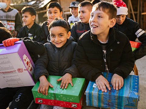 two boys with shoebox gifts
