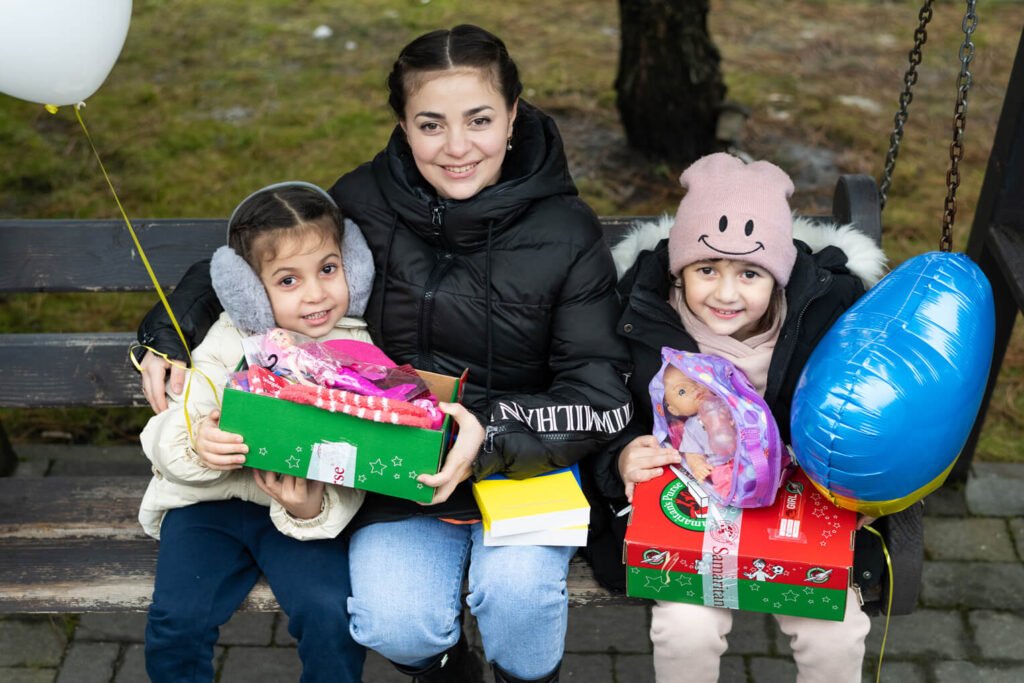 Vira is all smiles with her daughters Anastasia (right) and Ionna after receiving their shoebox gifts.
