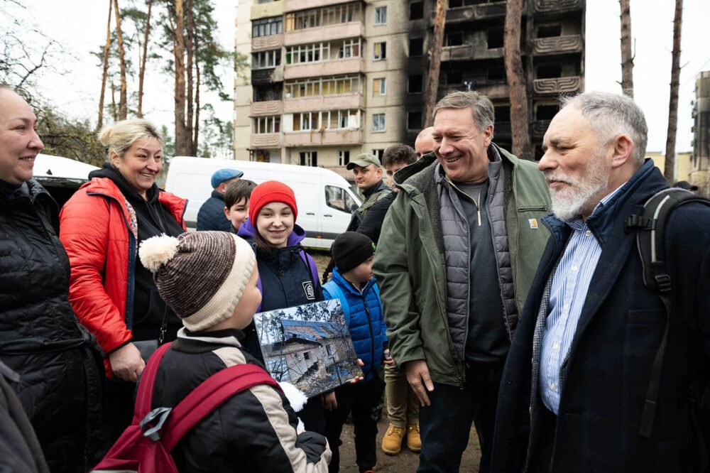 Mike Pompeo greets a child during the international delegation’s visit to Ukraine.